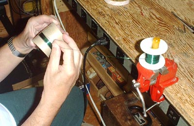 Place the spool over a screwdriver which is clamped in a small vise.  Hold the coil form and rotate it about it's axis.